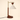 Dark wood post with a brass crane arm and cream cone shade, lamp off
