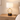 Wood ring table lamp on a quiet nightstand, shade on