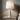 Marble Cone table lamp on a light oak nightstand beside linen bedding, lamp on