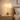 Smoky glass table lamp on a pale oak nightstand, shade on