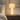 Hourglass table lamp on a quiet wood nightstand, shade on