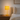 Small ochre bobbin table lamp on a quiet wood nightstand, shade on