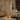 Brass triple-spot tree floor lamp beside a sofa, lit