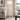 Brushed nickel swing-arm floor lamp beside a sofa in a quiet living room, lit