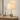 Smoky glass table lamp on a light wood console, shade on