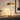 Gold pull-chain table lamp on a console with one ceramic vase, shade on