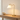 Brass ring table lamp on a wood console with a ceramic bowl, lamp on