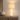 Hourglass table lamp on a console with one ceramic vase, shade on