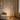 Brass triple-spot tree floor lamp in a quiet living-room corner, lit
