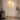 Gold two-globe tree floor lamp in a quiet living-room corner, lit