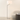 Brushed nickel swing-arm floor lamp next to a chair for scale, lit