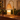 Amber Glass Tree Candle Warmer Lamp on a mantel with an evergreen garland