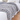 Grey chunky knit weighted blanket across the end of a bed with white bedding