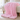 Pink chunky knit weighted blanket draped over a boucle bench at the foot of a bed