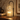 Clear Glass Tree Candle Warmer Lamp glowing on a dark oak sideboard in the evening