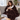 Woman on a sofa wrapped in the coffee heated throw blanket, holding a mug