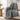 Gray weighted throw blanket draped over an armchair in a reading corner