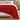 Red knit weighted blanket across the foot of a bed with white bedding
