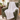 White knit weighted blanket draped over a green velvet armchair