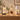 Three candle warmer lamps lit over jar candles on an oak console against a cream wall