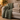 Sage green quilted weighted blanket draped over a cream sofa beside a folded oatmeal blanket
