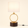 Dark wood cylinder with a vertical gold ring and a white fabric drum shade, lamp on