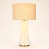Off-white glass hourglass table lamp with a tan linen drum shade, lamp on
