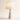Marble Cone table lamp with tapered white marble cone base, short gold neck, and white fabric drum shade, lamp on