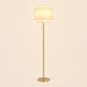 Gold tier floor lamp with three-step cream linen shade, lit, cream studio
