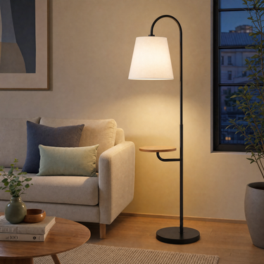 Same Seoul floor lamp beside a sofa, cream shade on, tall floor scale clear.