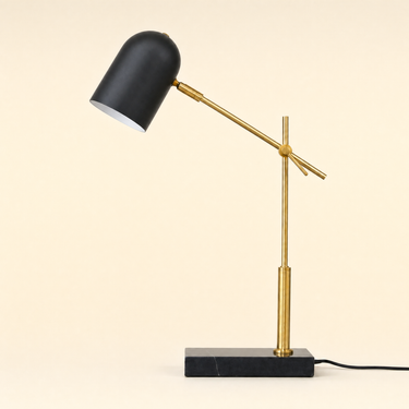 Black marble desk lamp with a brass crane arm and matte-black pill shade, lamp off