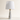 Marble Cone table lamp with tapered white marble cone base, short gold neck, and unlit white fabric drum shade, lamp off