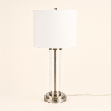 Brushed nickel table lamp with a clear glass cylinder and white fabric shade, lamp off
