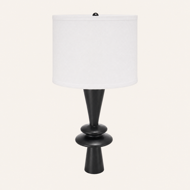 Matte black stacked-disc table lamp with a tall white fabric drum shade, lamp off