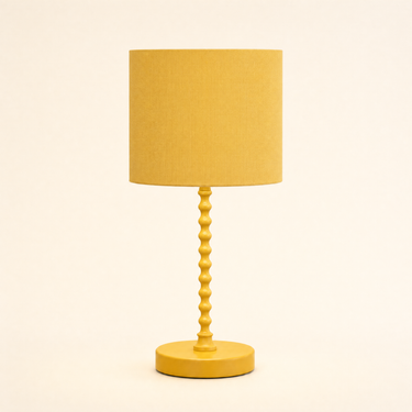Ochre yellow bobbin table lamp with a matching mustard drum shade, lamp off