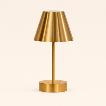 Small brass cordless table lamp with a metal cone shade, lamp off