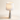 Three-quarter view of the Marble Cone table lamp with tapered white marble cone base and white fabric drum, lamp on
