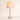 Three-quarter view of the washed-white spindle table lamp, lamp on