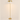 Three-quarter view of the gold dome floor lamp, lit, cream studio