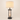 Three-quarter view of the farmhouse table lamp with cream linen shade and bronze lantern cage, lamp on