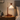 Wood crane arm table lamp on a quiet nightstand, shade on