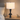 Stacked-disc table lamp on a pale oak nightstand, shade on