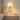 Wood tripod table lamp on a quiet nightstand, shade on