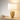Gold mesh table lamp on a light wood console with one ceramic bowl, shade on