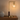 L-neck globe table lamp on a console with one ceramic vase, globe on