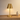 Brass cordless table lamp on a console with one ceramic vase, shade on