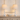 Pair of washed-white spindle table lamps on a console with one ceramic bowl, both lamps on