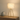 Marble tripod table lamp on a console with one ceramic vase, shade on