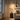 Brass pharmacy floor lamp in a quiet living-room corner, lit