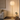 Gold tier floor lamp in a quiet living room corner, lit